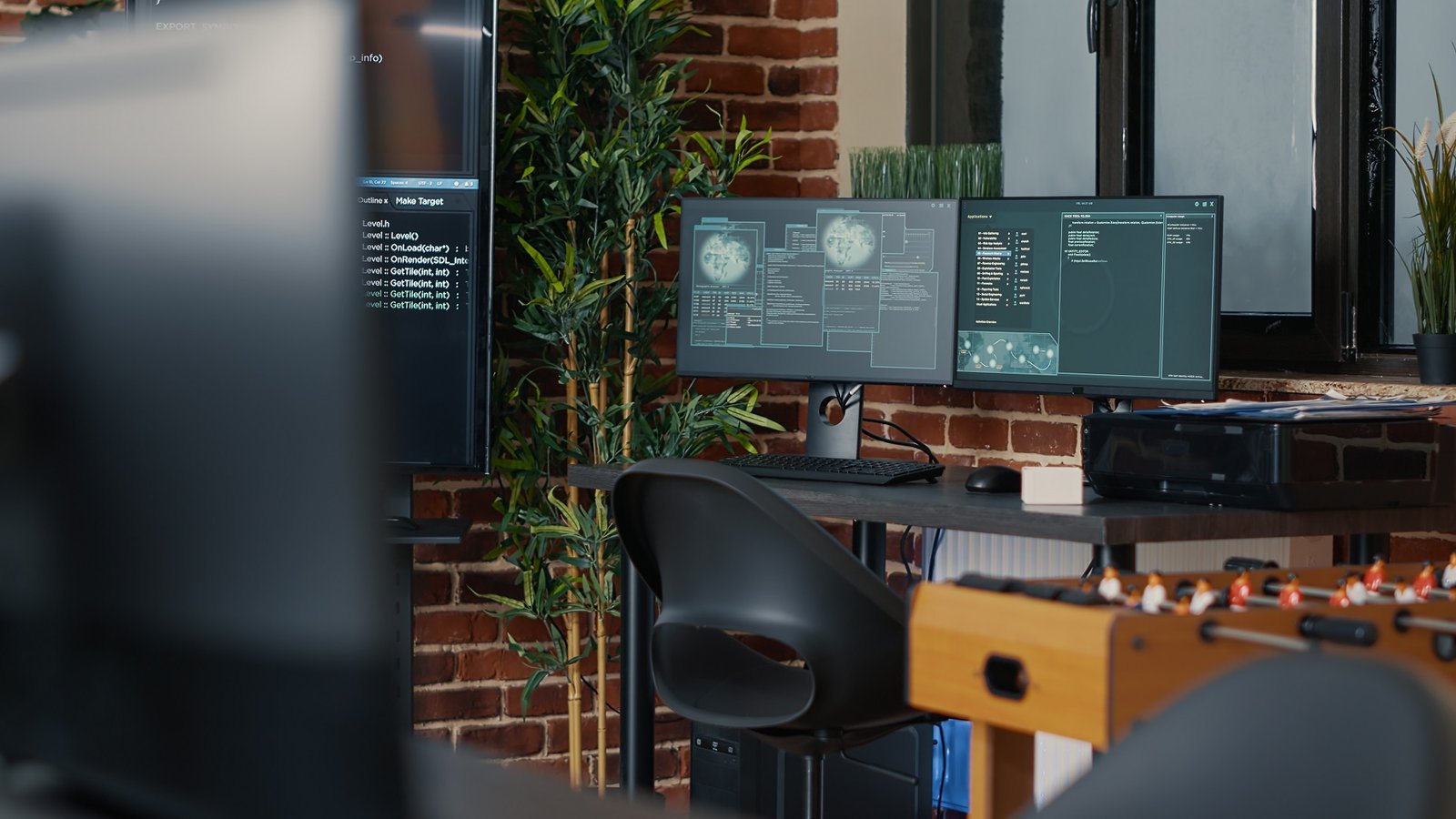 Espace de travail moderne avec plusieurs écrans d’ordinateur affichant du code, sur un bureau design devant un mur en briques, illustrant l’univers du web design.